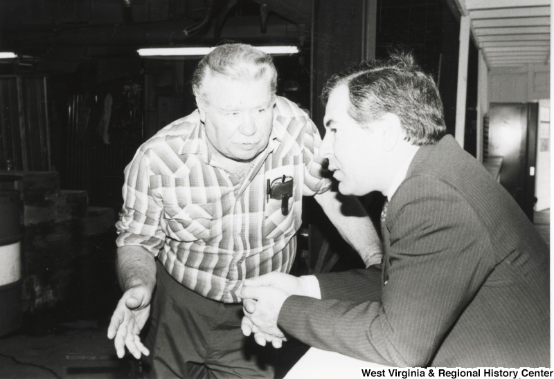 On the right, Representative Nick J. Rahall (D-W.Va.) tlaks with an unidentified man.